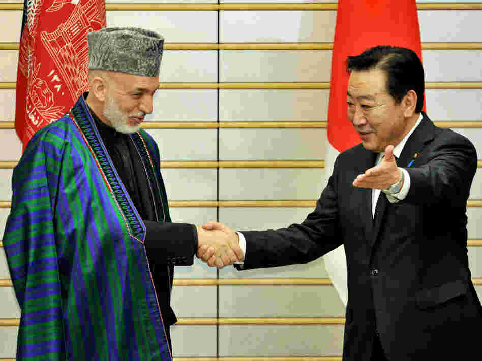 Afghan President Hamid Karzai is greeted by Japanese Prime Minister Yoshihiko Noda in Tokyo on July 9. The international community recently pledged $16 billion in additional aid, but wants Karzai to crack down on rampant corruption.