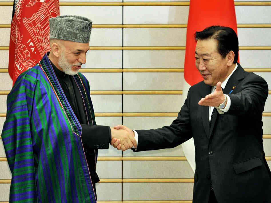 Afghan President Hamid Karzai is greeted by Japanese Prime Minister Yoshihiko Noda in Tokyo on July 9. The international community recently pledged $16 billion in additional aid, but wants Karzai to crack down on rampant corruption.