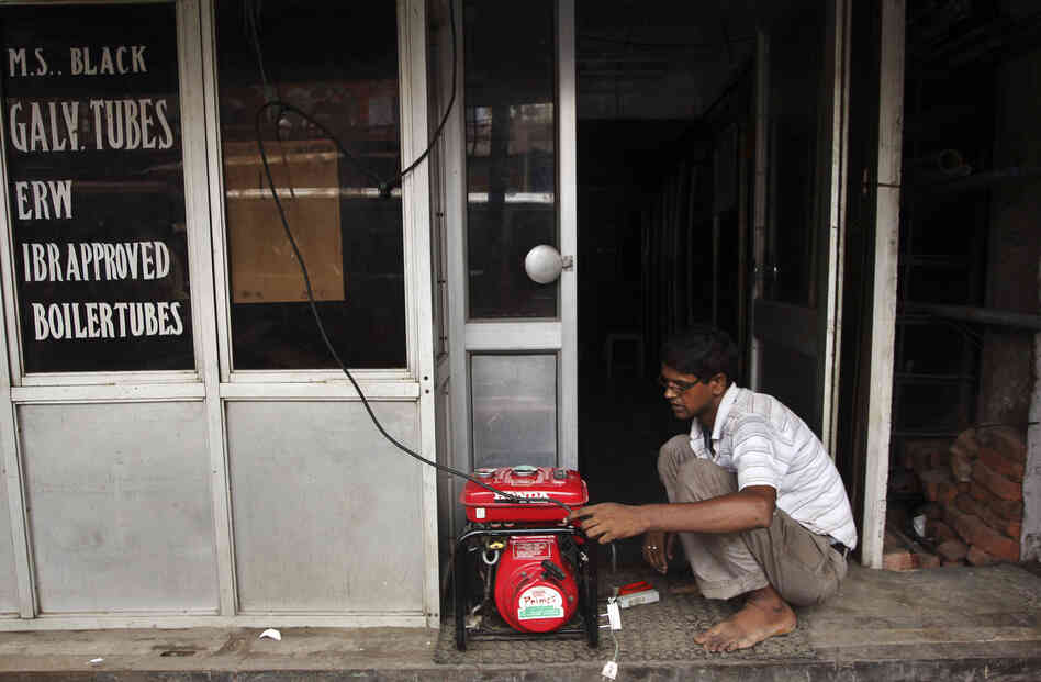A shopkeeper fixes an electric generator at his shop in New Delhi.