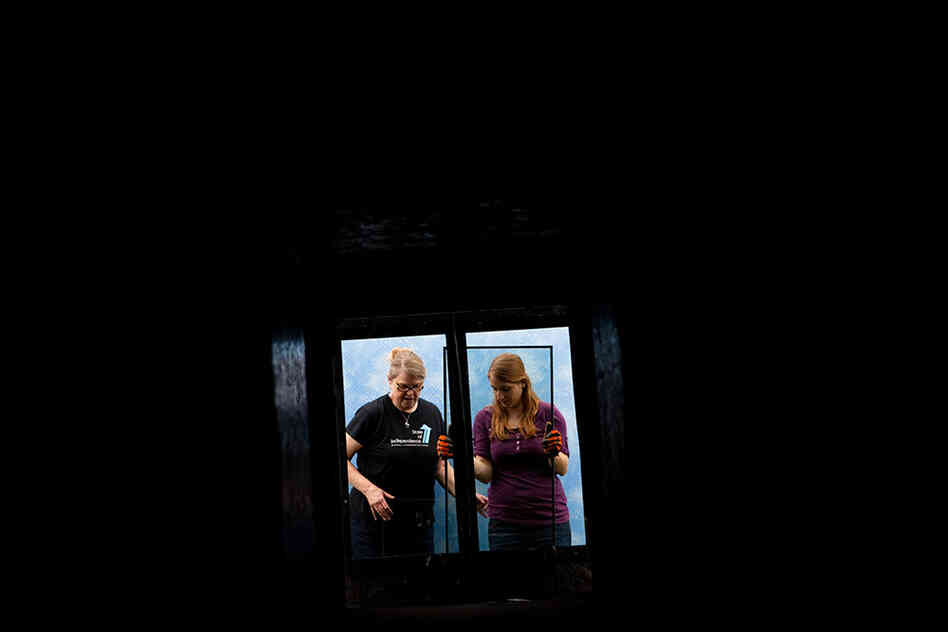 Christine Sheppard (left), an ornithologist with the American Bird Conservancy, and her assistant, Cara Menzel, insert two panes of glass into a test tunnel. One pane is a regular piece of glass; the other has a pattern of lines painted on the inside that reflects ultraviolet light. The birds can see the pattern, but it is barely detectable by the human eye.