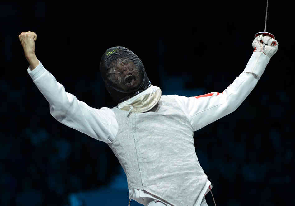 China's Lei Sheng celebrates his victory over Egypt's Alaaeldin Abouelkassem at the end of their Men's foil gold medal bout.