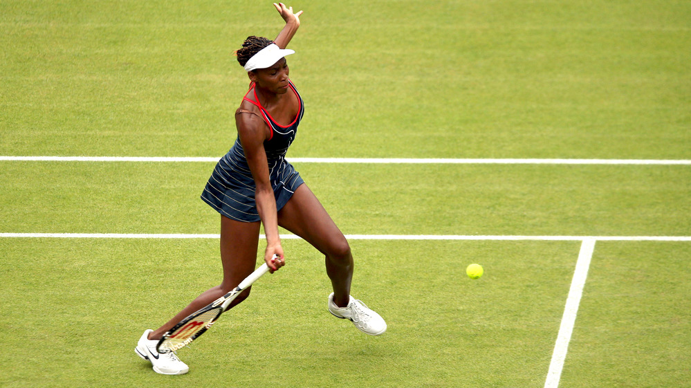 Venus Williams of the United States returns a shot to Aleksandra Wozniak of Canada in their Olympic singles tennis match, played at Wimbledon. Williams won, 6-1, 6-3.