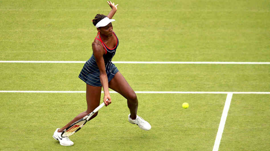 Venus Williams of the United States returns a shot to Aleksandra Wozniak of Canada in their Olympic singles tennis match, played at Wimbledon. Williams won, 6-1, 6-3.