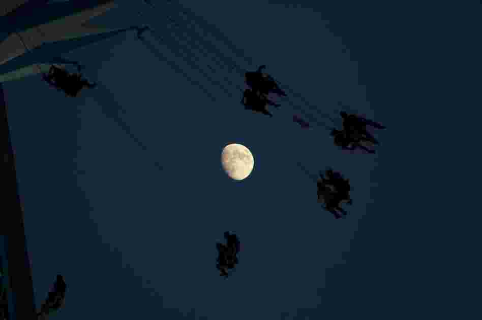A waxing moon in the background of a fairground attraction in London on Sunday.