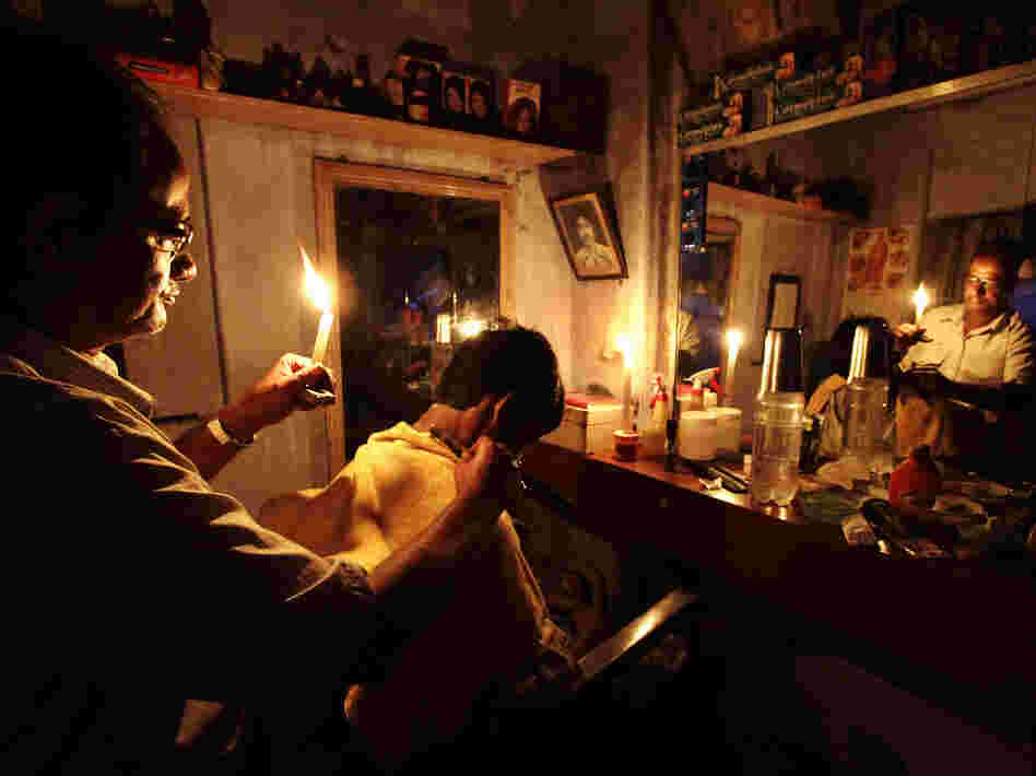 During the blackout on Tuesday, an Indian barber cut hair by candlelight in his shop in Kolkata.