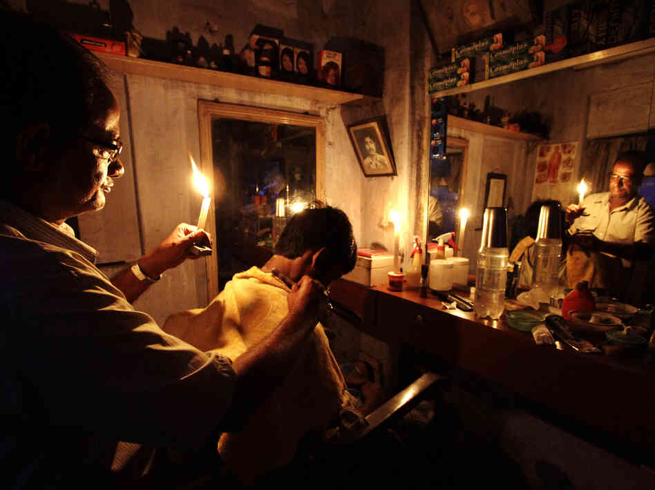 During the blackout on Tuesday, an Indian barber cut hair by candlelight in his shop in Kolkata.