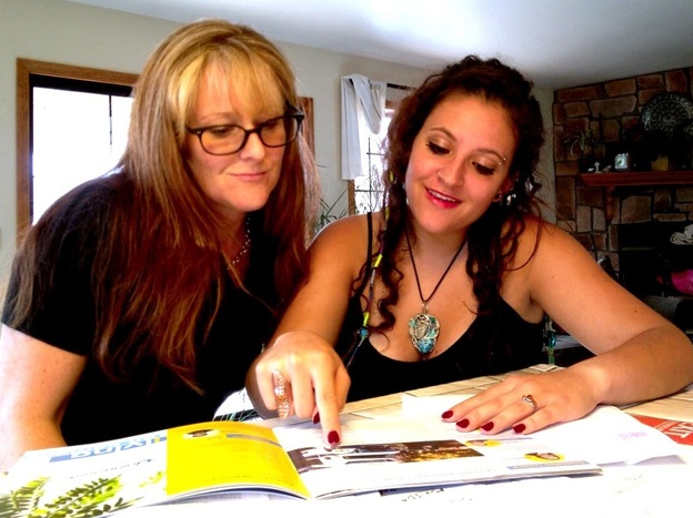 Emily Macri looks over a college brochure with her mother, Maureen O'Brien, in Kingman, Ariz. Macri is transferring to Northern Arizona University so that she can pay in-state tuition.