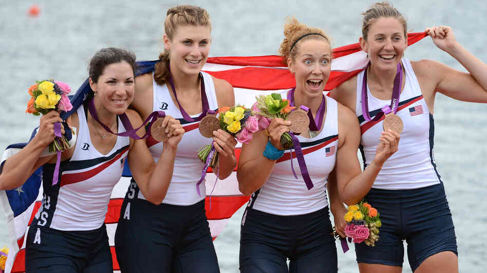 Adrienne Martelli, Megan Kalmoe, Kara Kohler and Natalie Dell of the United States celebrate on the podium after winning bronze in the women's quadruple sculls at Eton Dorney in Windsor, England.