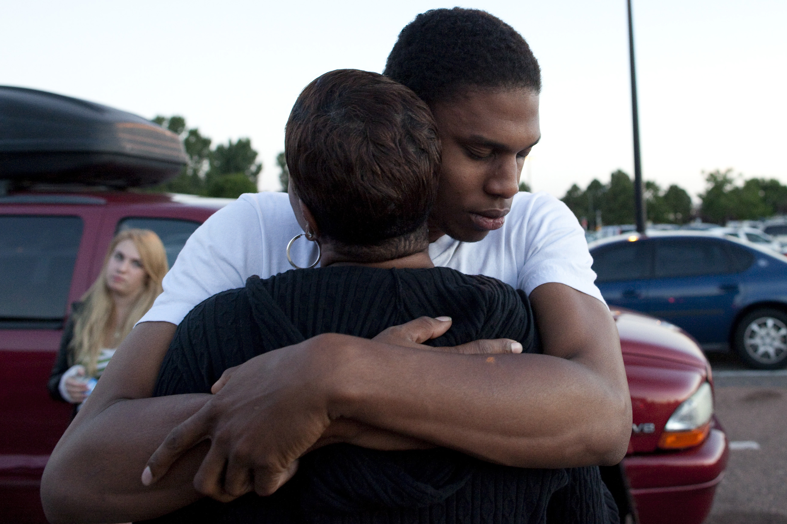 Isaiah Bow hugs his mother, Shamecca Davis, after being questioned by police outside Gateway High School where he and other witnesses were brought after the shooting. After leaving the theater Bow went back in to find his girlfriend. "I didn't want to leave her in there. But she's OK now," Bow said.
