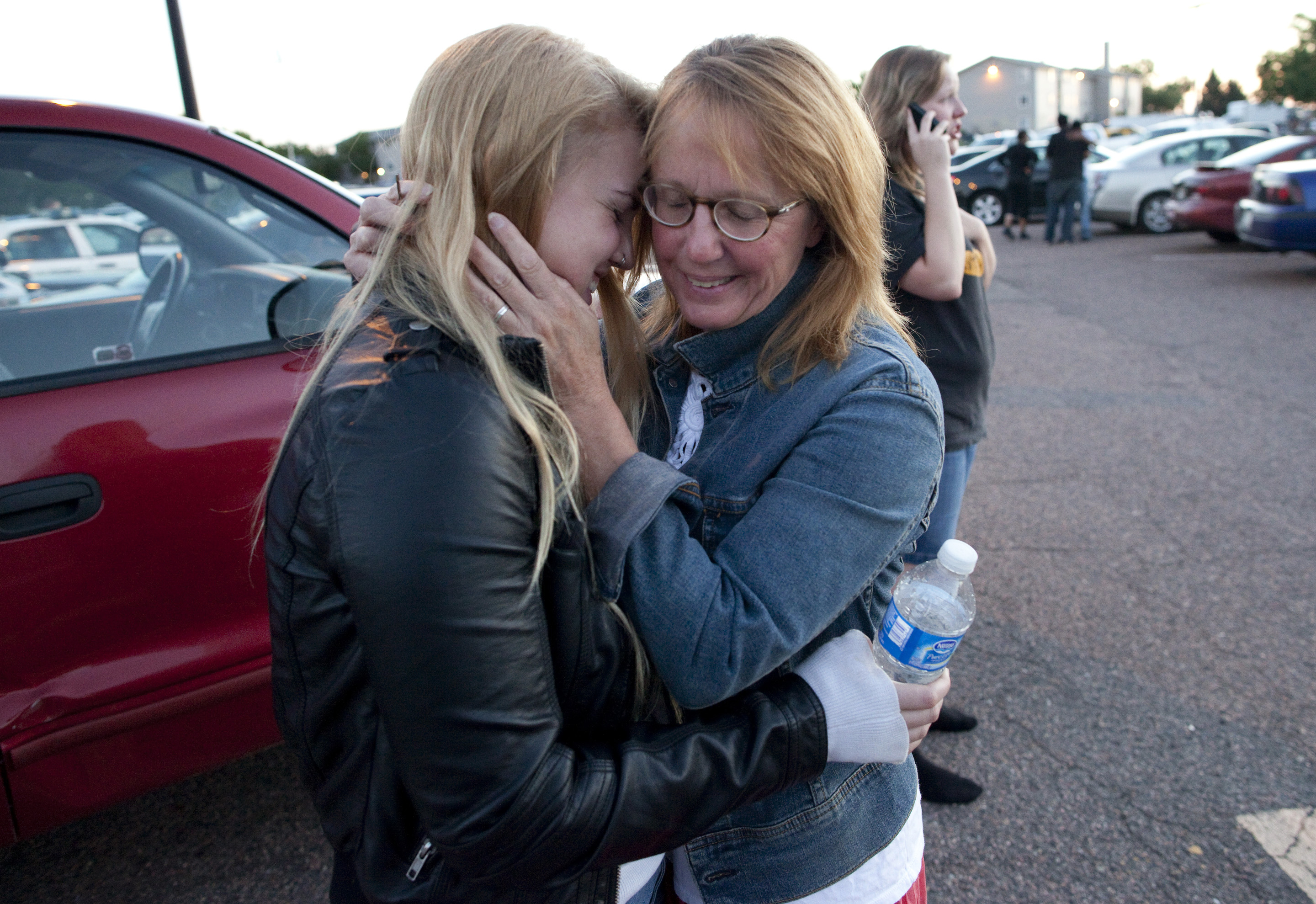 Emma Goos, 19, hugs her mother, Judy Goos, outside the high school. Emma was in the third row of the theater when the shooter entered. She helped apply pressure to an injured man's head.