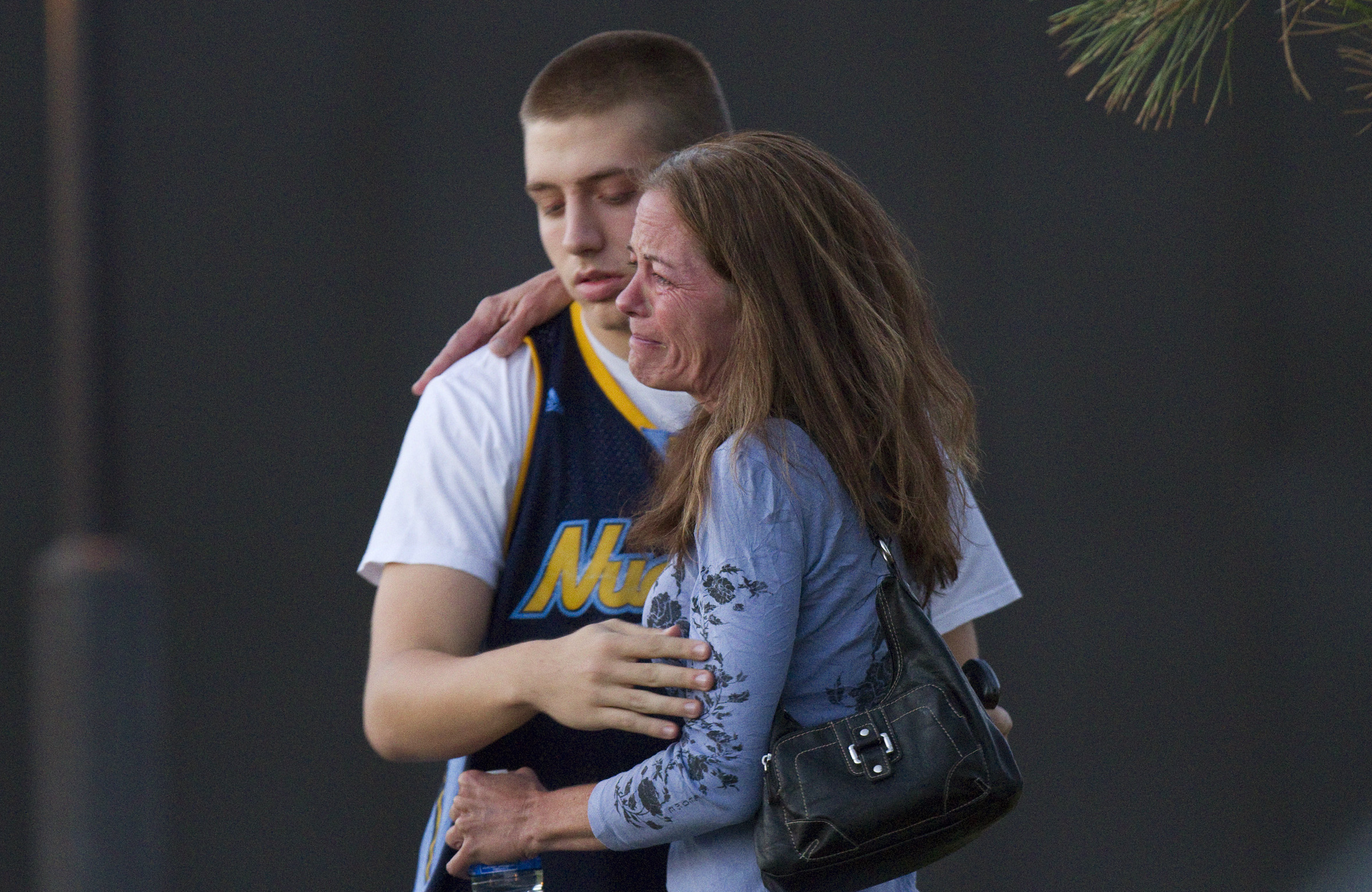 Eyewitness Jacob Stevens, 18, hugs his mother, Tammi Stevens, after being interviewed by police.