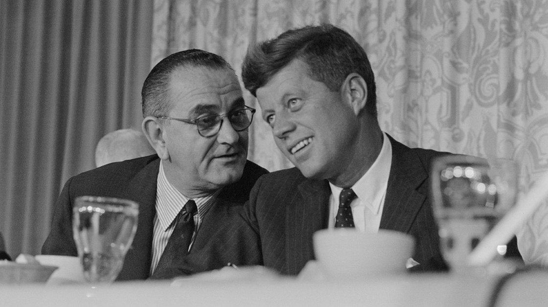 John F. Kennedy smiles as Lyndon Johnson speaks to him at breakfast during the time of the 1960 Democratic convention in Los Angeles.