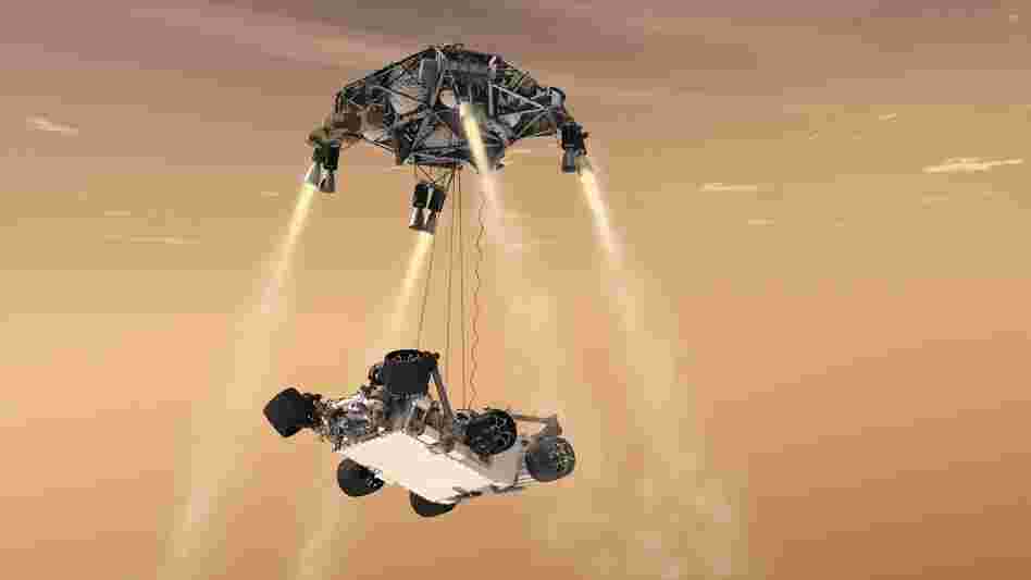 Here's where things get crazy. A new "sky crane" lowers the rover on three cables while hovering above the surface. 