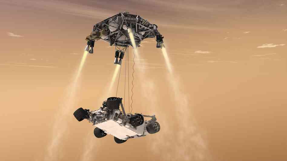 Here's where things get crazy. A new "sky crane" lowers the rover on three cables while hovering above the surface. 