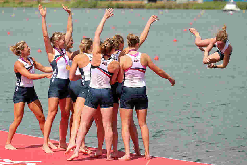The U.S. rowing team throws their cox Mary Whipple into the water as they celebrate during the medal ceremony.