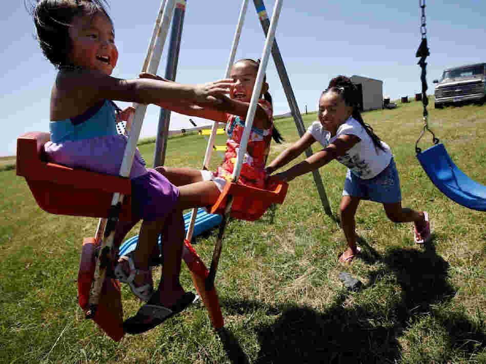 Daylyn, 3, Rashauna, 6, and Antoinette, 8, play on a swing set in their great grandparents' back yard on the Crow Creek Reservation. The children were taken from their mother, by South Dakota's Department of Social Services they spent a year and a half in foster care, despite the fact that she was never arrested or charged with any thing.