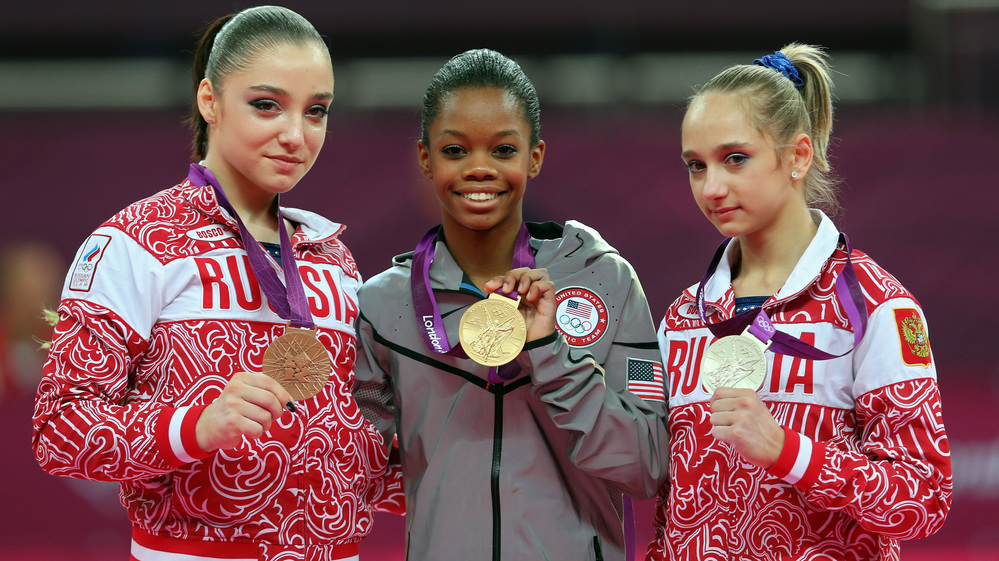 Who's The Happiest? Researchers studied photos of Olympic medalists to learn who is the happiest. Here, bronze medalist Aliya Mustafina of Russia, gold medalist Gabby Douglas of the U.S., and silver medalist Victoria Komova of Russia pose after the all-around gymnastics final.