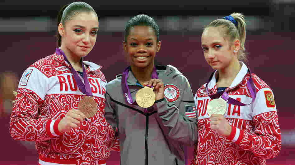 Who's The Happiest? Researchers studied photos of Olympic medalists to learn who is the happiest. Here, bronze medalist Aliya Mustafina of Russia, gold medalist Gabby Douglas of the U.S., and silver medalist Victoria Komova of Russia pose after the all-around gymnastics final.