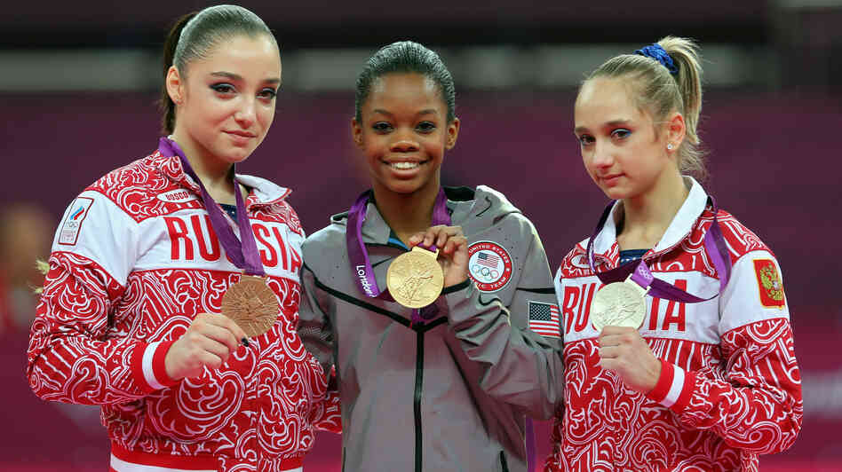 Who's The Happiest? Researchers studied photos of Olympic medalists to learn who is the happiest. Here, bronze medalist Aliya Mustafina of Russia, gold medalist Gabby Douglas of the U.S., and silver medalist Victoria Komova of Russia pose after the all-around gymnastics final.