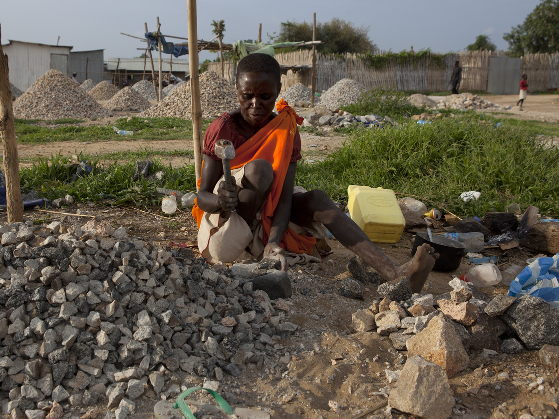 A woman pounds rocks for a few dollars a day in Juba, South Sudan.