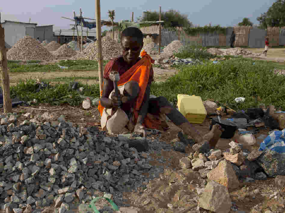 A woman pounds rocks for a few dollars a day in Juba, South Sudan.