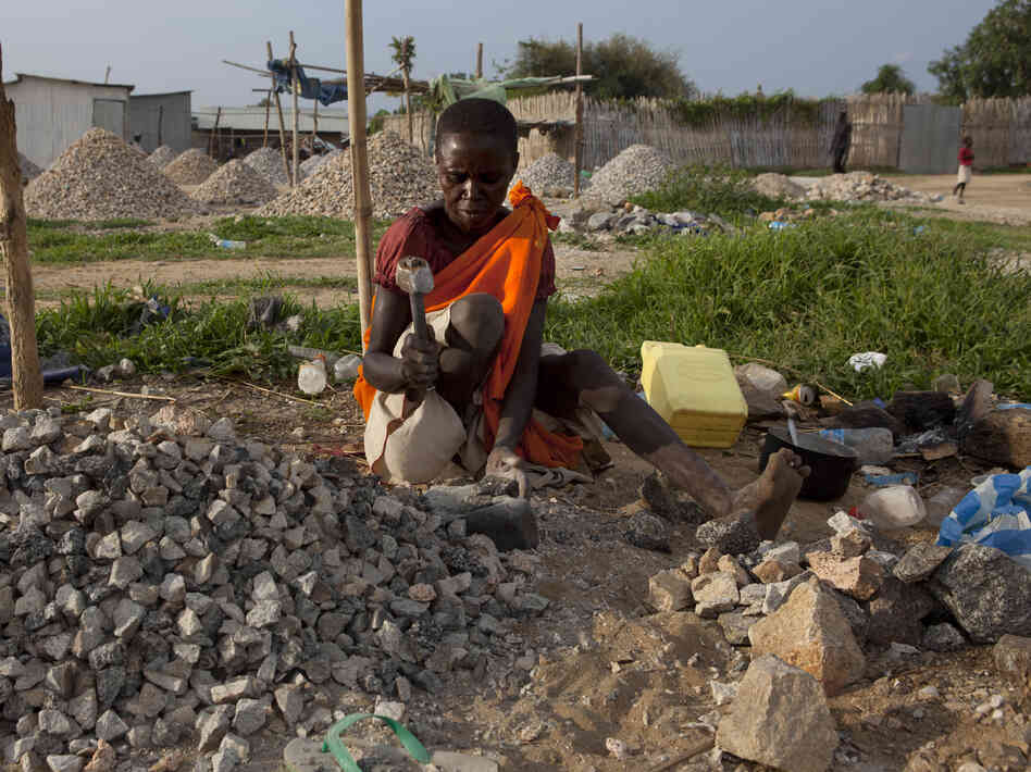 A woman pounds rocks for a few dollars a day in Juba, South Sudan.