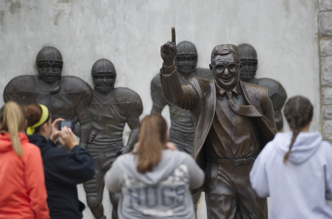 Visitors gather around the statue of former Penn State football coach Joe Paterno outside Beaver Stadium Saturday in State College, Pa.