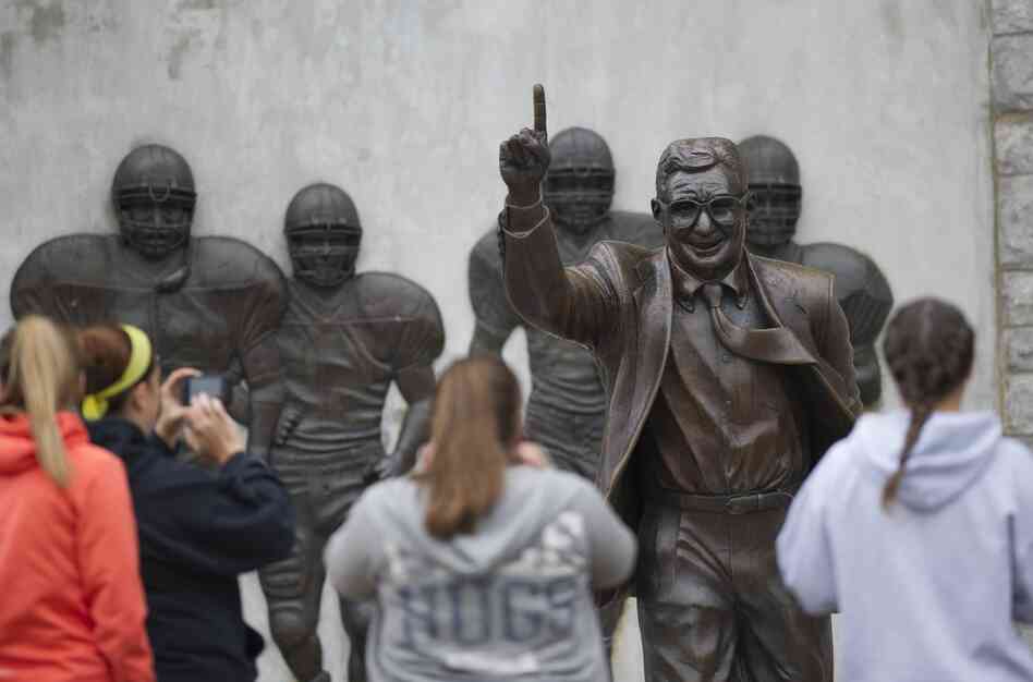 Visitors gather around the statue of former Penn State football coach Joe Paterno outside Beaver Stadium Saturday in State College, Pa.