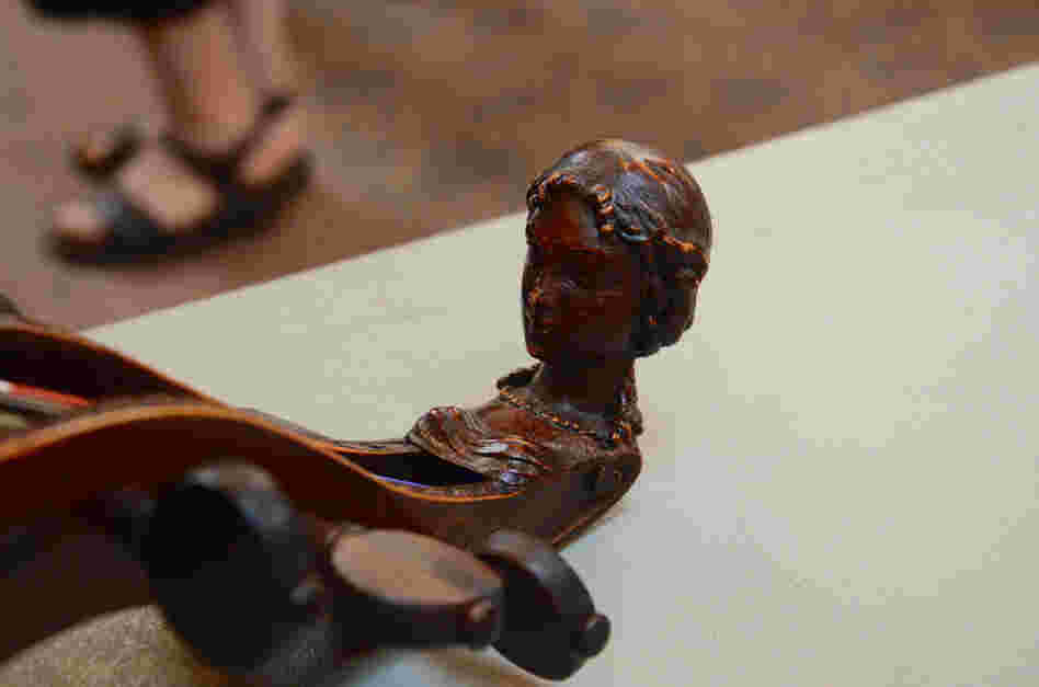 A traditional carved head on an original, early 18th-century bass viol.