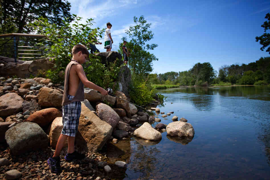 Children fish at a newly opened recreational area built by Enbridge on the Kalamazoo River. Posted signs warn that most of the fish is not safe to eat. These children were not aware of the oil spill and were not area residents.