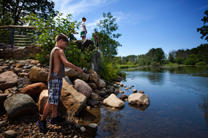 Children fish at a newly opened recreational area built by Enbridge on the Kalamazoo River. Posted signs warn that most of the fish is not safe to eat. These children were not aware of the oil spill and were not area residents.
