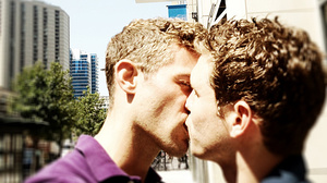 As part of a protest, two men kiss in front of a Chick-fil-A.