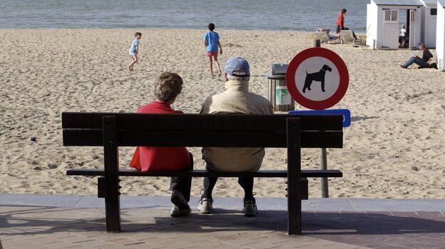 People enjoy a sunny day on the beach in Knokke, on Belgium's North Sea coast, in  April 2011. This summer, the weather hasn't been as nice — and resort owners and officials are feeling litigious over a pessimistic weather forecast.
