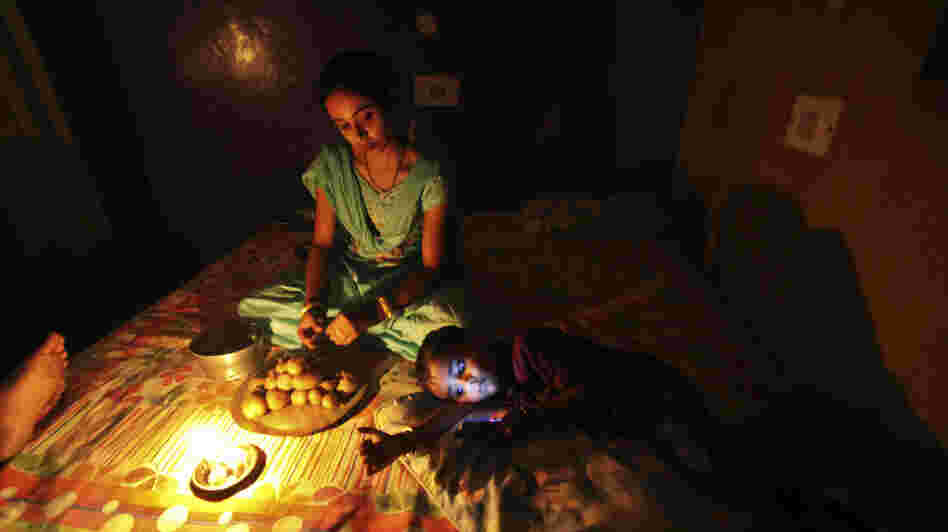 A girl prepares a meal by candlelight in Jammu, India, during the massive blackout last week.