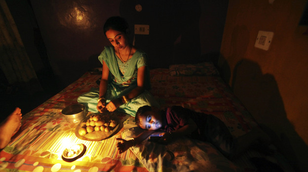A girl prepares a meal by candlelight in Jammu, India, during the massive blackout last week. (AP)