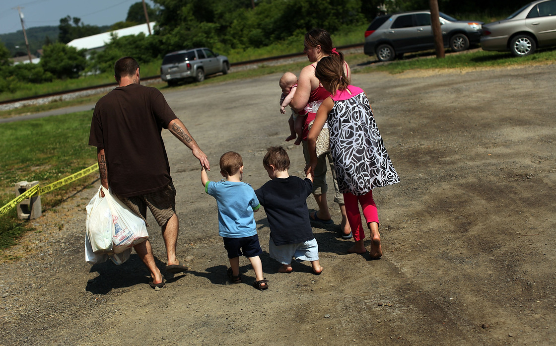 Members of the Dolan family walk home with bags of food from the Southern Tier Mobile Food Pantry in Oswego, N.Y., in June. Food banks across the nation are reporting giant spikes in demand.