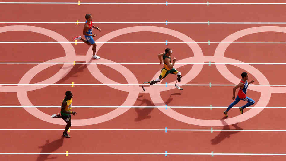 Oscar Pistorius of South Africa, center, became the first amputee to run in the Olympics. He came in second to Luguelin Santos of the Dominican Republic, to advance to the men's 400m semifinals.