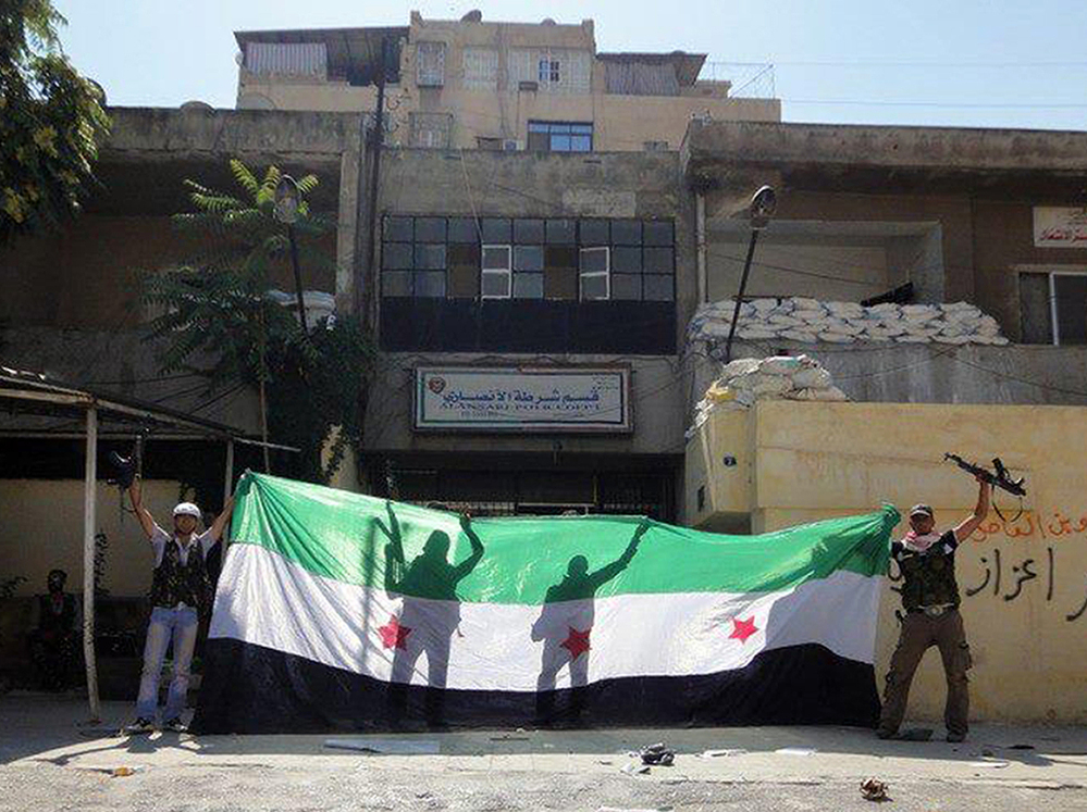 A picture released by the Syrian opposition's Shaam News Network purportedly shows Syrian rebels celebrating after taking over a police station in the Ansari district of Aleppo on Friday.