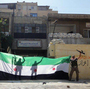 A picture released by the Syrian opposition's Shaam News Network purportedly shows Syrian rebels celebrating after taking over a police station in the Ansari district of Aleppo on Friday.
