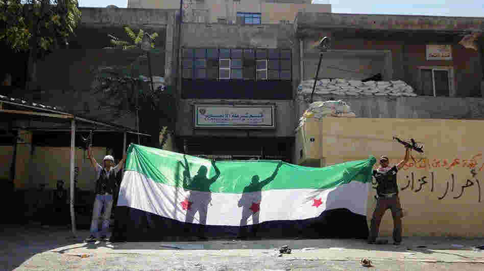 A picture released by the Syrian opposition's Shaam News Network purportedly shows Syrian rebels celebrating after taking over a police station in the Ansari district of Aleppo on Friday.