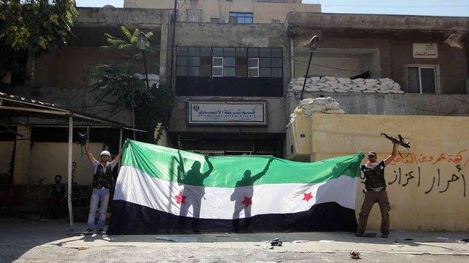 A picture released by the Syrian opposition's Shaam News Network purportedly shows Syrian rebels celebrating after taking over a police station in the Ansari district of Aleppo on Friday.