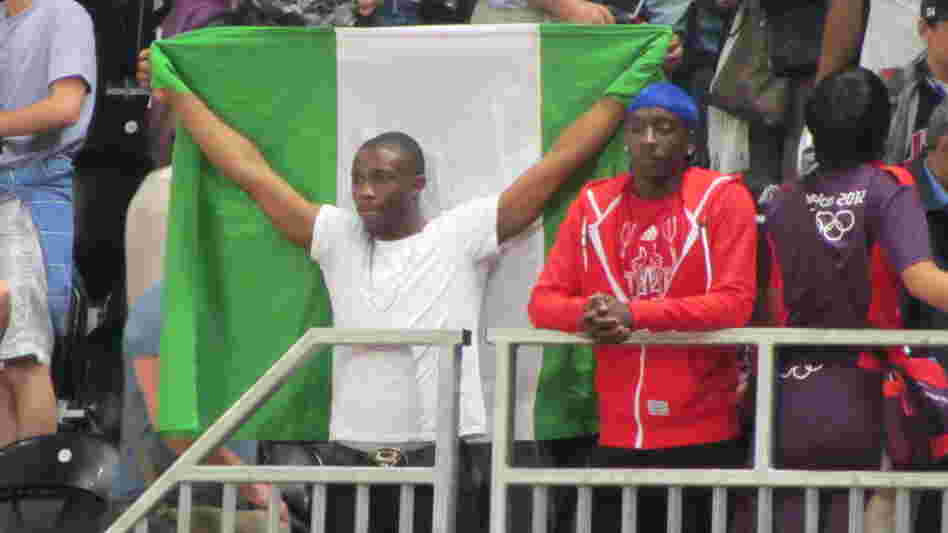 Nigerian fan Ifeoluwa Akande holds his country's flag as he watches Nigeria's basketball team lose to the United States by a record 83 points.