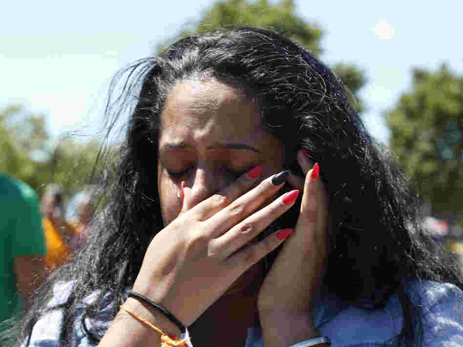 A woman waits outside the Sikh Temple of Wisconsin in Oak Creek, Wis, where a gunman opened fire and killed six people. The gunman was killed by police.
