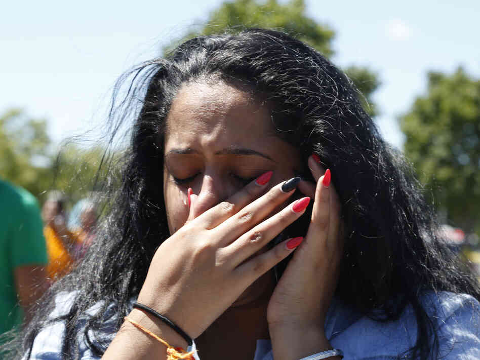 A woman waits outside the Sikh Temple of Wisconsin in Oak Creek, Wis, where a gunman opened fire and killed six people. The gunman was killed by police.