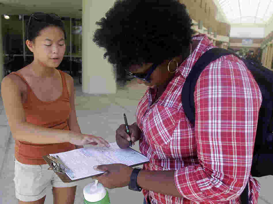 Aubrey Marks (left) helps a University of Central Florida student to register to vote in Orlando, Fla., on July 31.