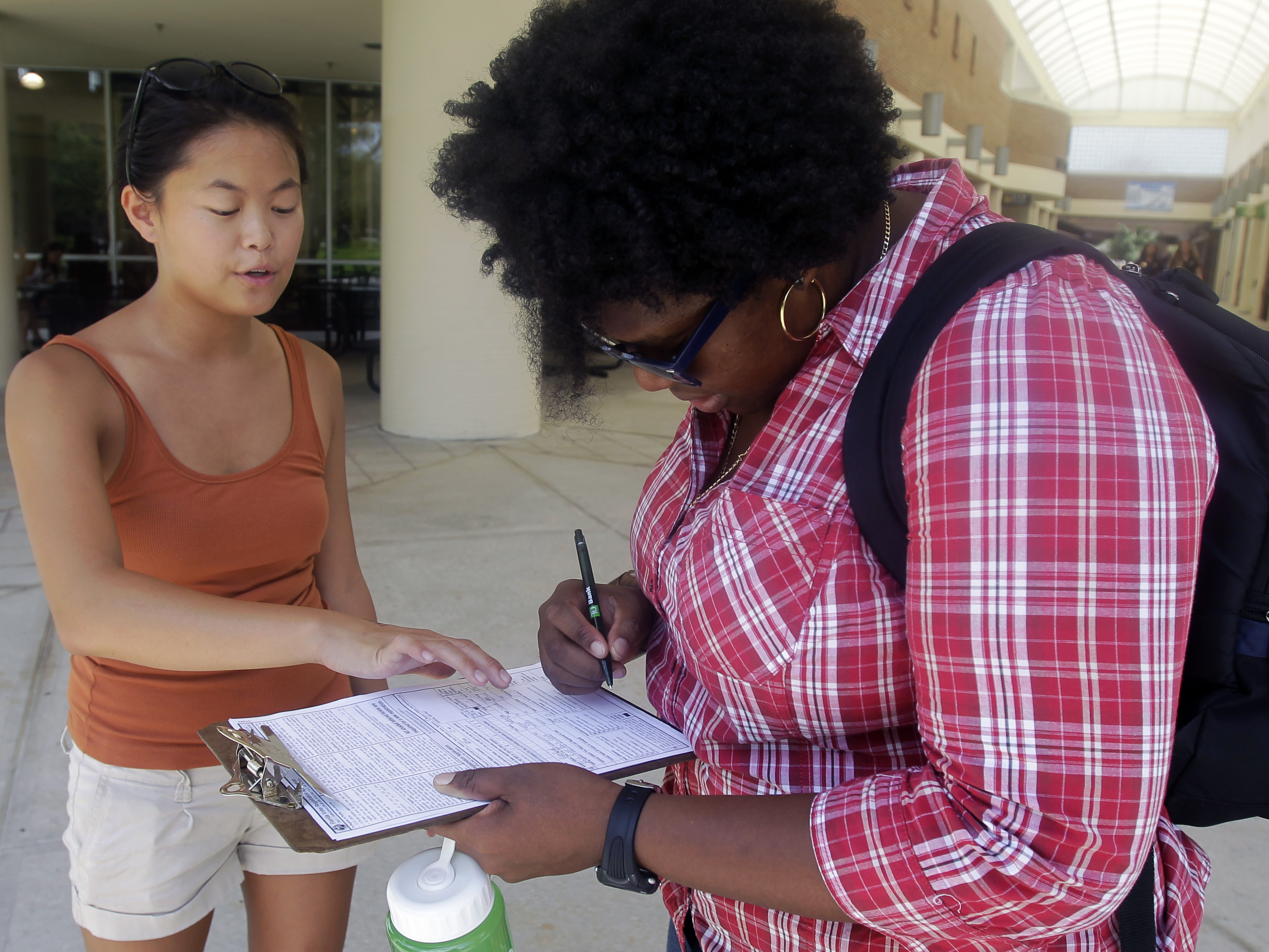 Aubrey Marks (left) helps a University of Central Florida student to register to vote in Orlando, Fla., on July 31.