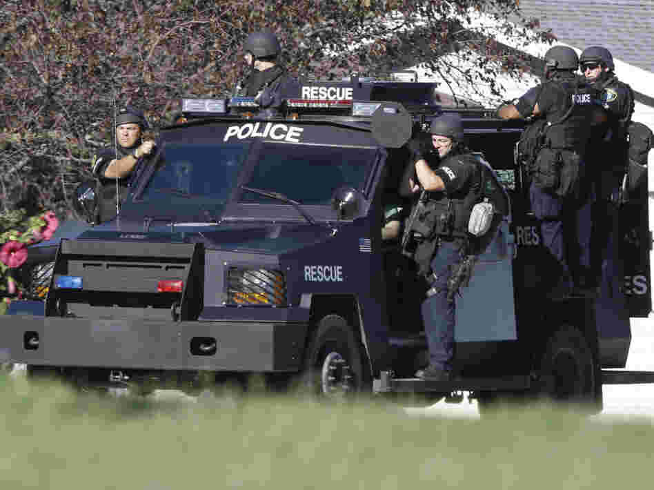 Police personnel drive around the temple after the shooting.