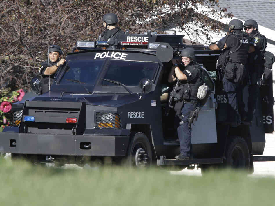 Police personnel drive around the temple after the shooting.