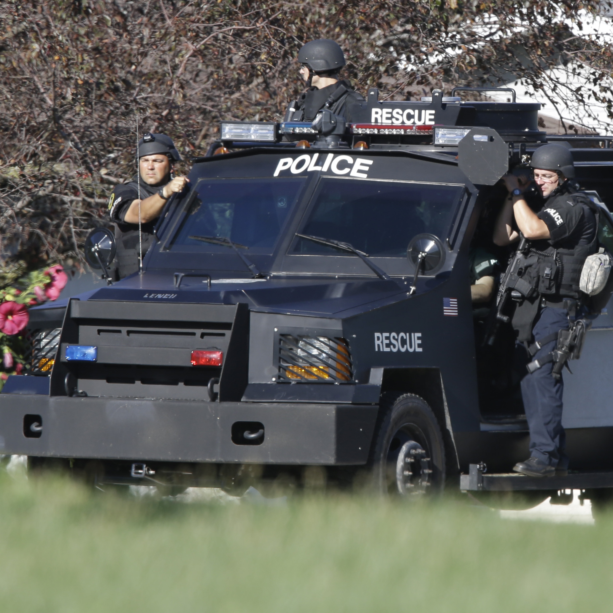 Police personnel drive around the temple after the shooting.