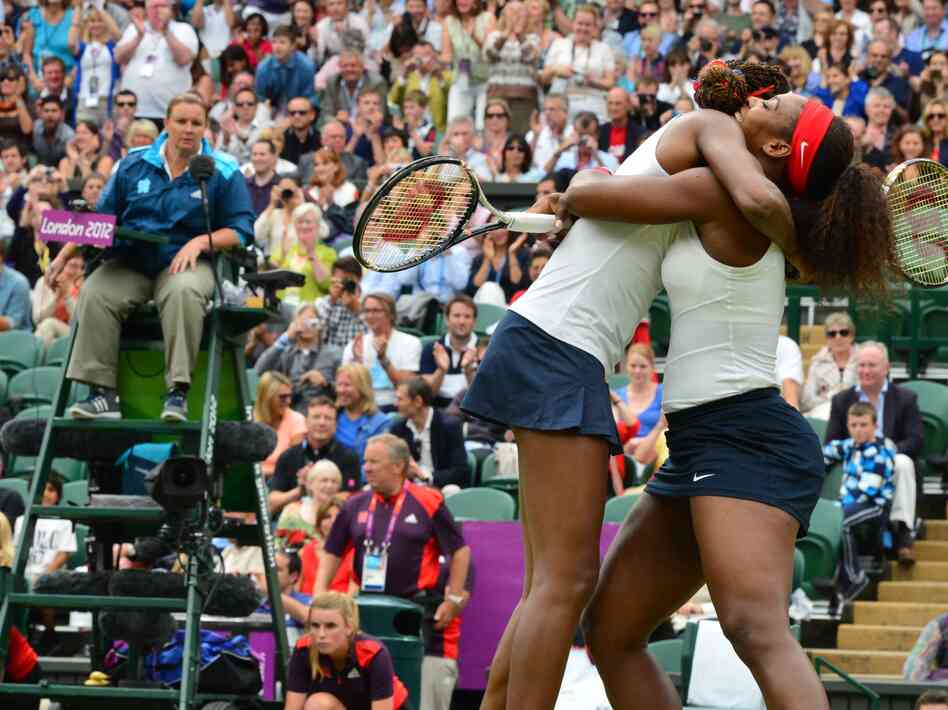 Venus (left) and Serena Williams celebrate after winning the women's doubles gold medal match today.